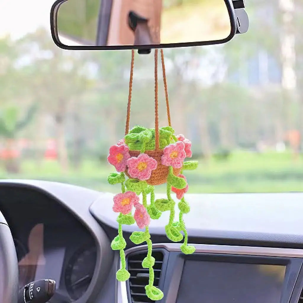 Strawberry crochet hanging decor with pink and green flowers suspended from a rearview mirror in a car