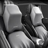 A close-up view of a gray ergonomic car headrest cushion designed for lumbar and cervical spine support.