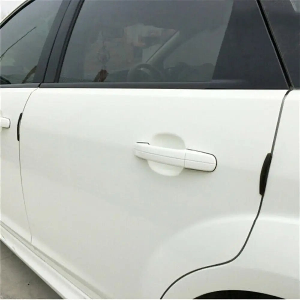 Close-up of a white car door featuring an installed anti-scratch guard trim strip.