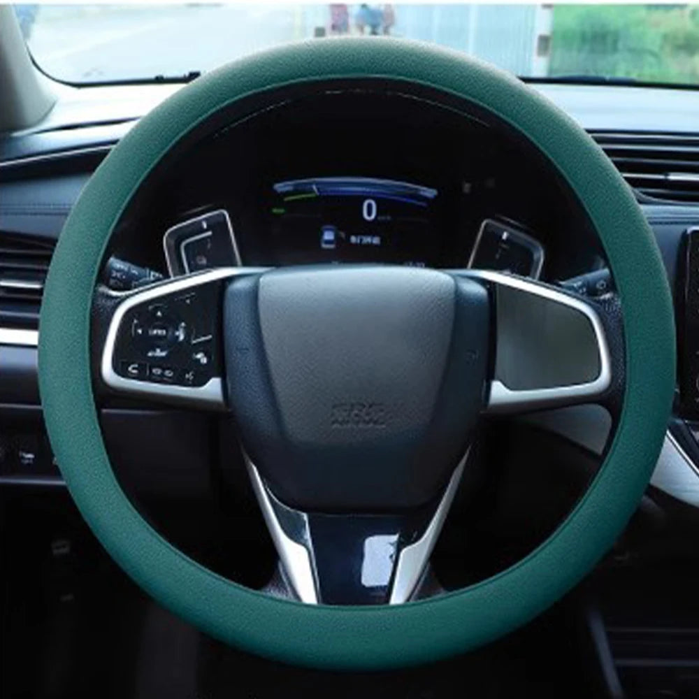 Nahaufnahme einer grünen Silikon-Lenkrad-Schutzabdeckung auf dem Lenkrad eines Autos.