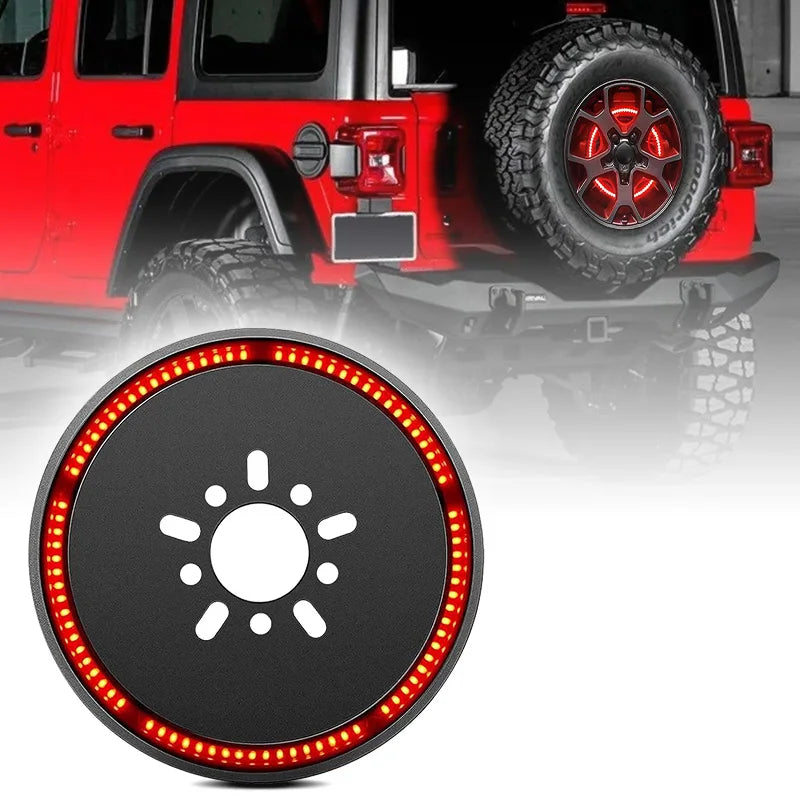 Close-up of a round LED replacement spare tire brake light mounted on the rear of a red Jeep Wrangler.