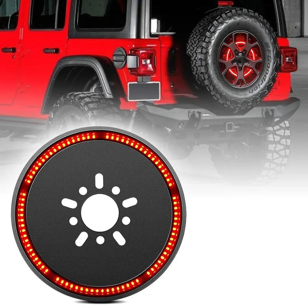 Close-up of a round LED replacement spare tire brake light mounted on the rear of a red Jeep Wrangler.