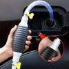 A hand holds a manual liquid transfer pump with a clear tube and yellow connector, demonstrating its use.
