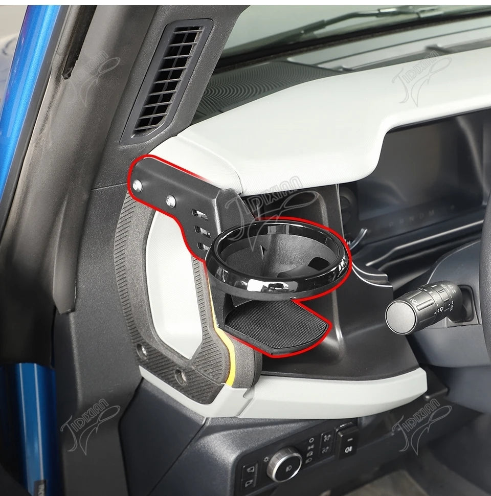 Close-up of a white Ford Bronco A-Pillar handle cup holder mounted on the interior door panel.