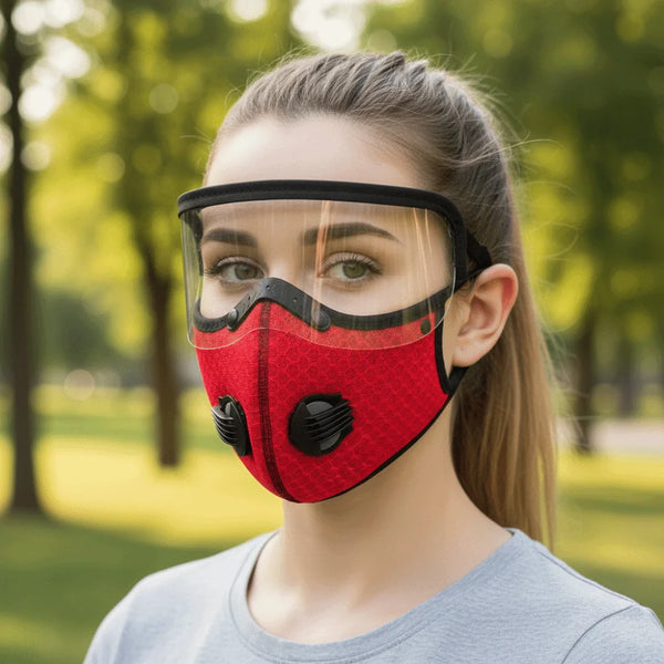 A woman wearing a red breathable cycling and outdoor face mask with clear protective goggles outdoors.