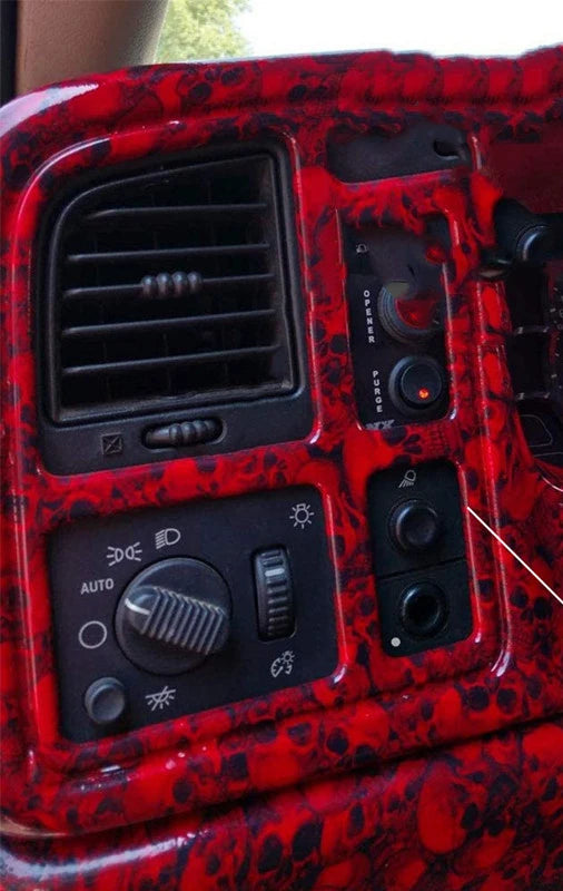 Gros plan d'un panneau de commutateur de phare à brouillard en plastique texturé rouge pour véhicules GM.