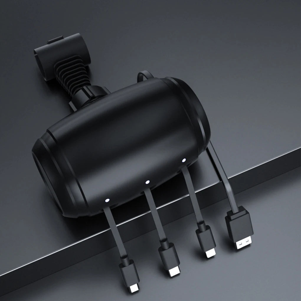 A black retractable car headrest charging cable with multiple electrical connectors lying on a gray surface.