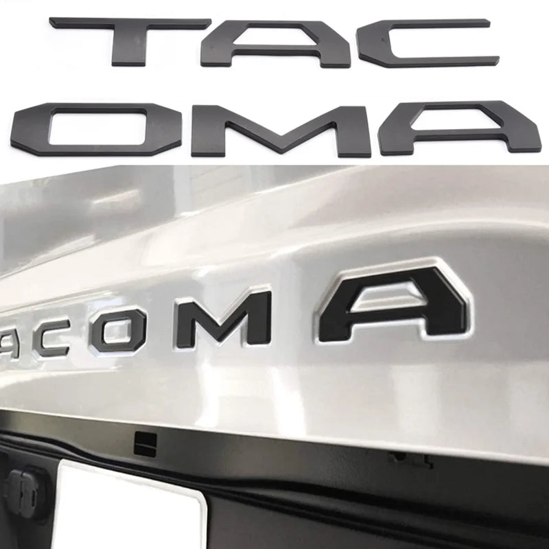 Black 3D letter cover emblem for a Toyota Tacoma tailgate featuring the word TACOMA.