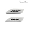 Two white Bose car audio emblems, measuring 4.5cm by 1.5cm.