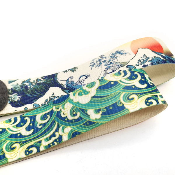 A close-up of a JDM car keychain lanyard featuring a blue and green wave pattern on a beige strap.