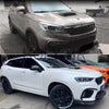 Un SUV blanc avec garniture de capot noire et pare-chocs avant personnalisé.