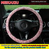 A pink leopard print plush steering wheel cover installed on a black car steering wheel.