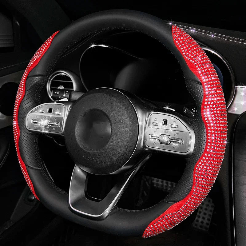 Volant noir avec une poignée en diamant rouge et les commandes visibles dans l'habitacle d'une voiture.