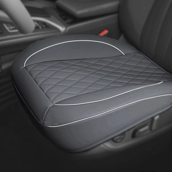 A close-up view of a gray PU leather car seat cover protector for a driver's seat, featuring diamond stitching.