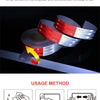 Roll of red and white reflective safety tape being used for fastening or sealing a surface.