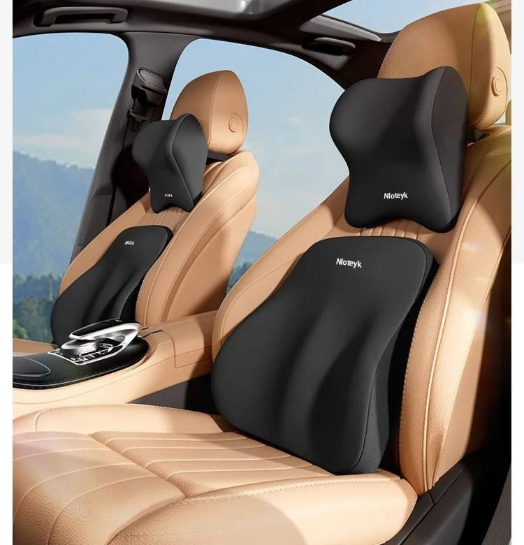 A black ergonomic lumbar support pillow is shown installed in the seat of a car, designed for travel.
