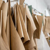 A rack of tan and beige fabric car seat covers hanging on a metal hanger.