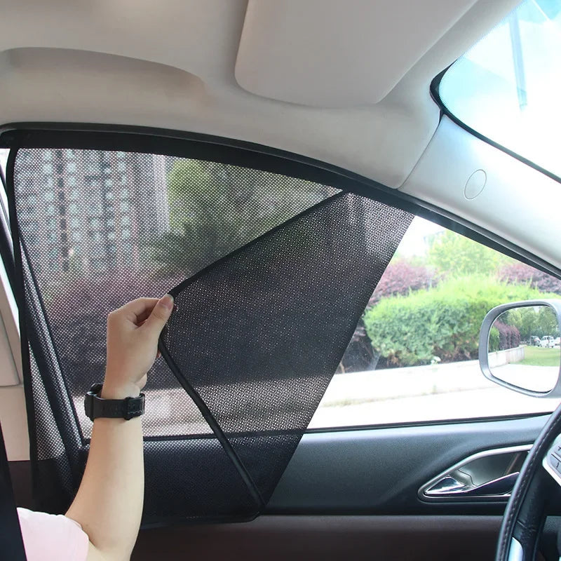 A hand is adjusting a magnetic car window sunshade for UV protection inside a vehicle.