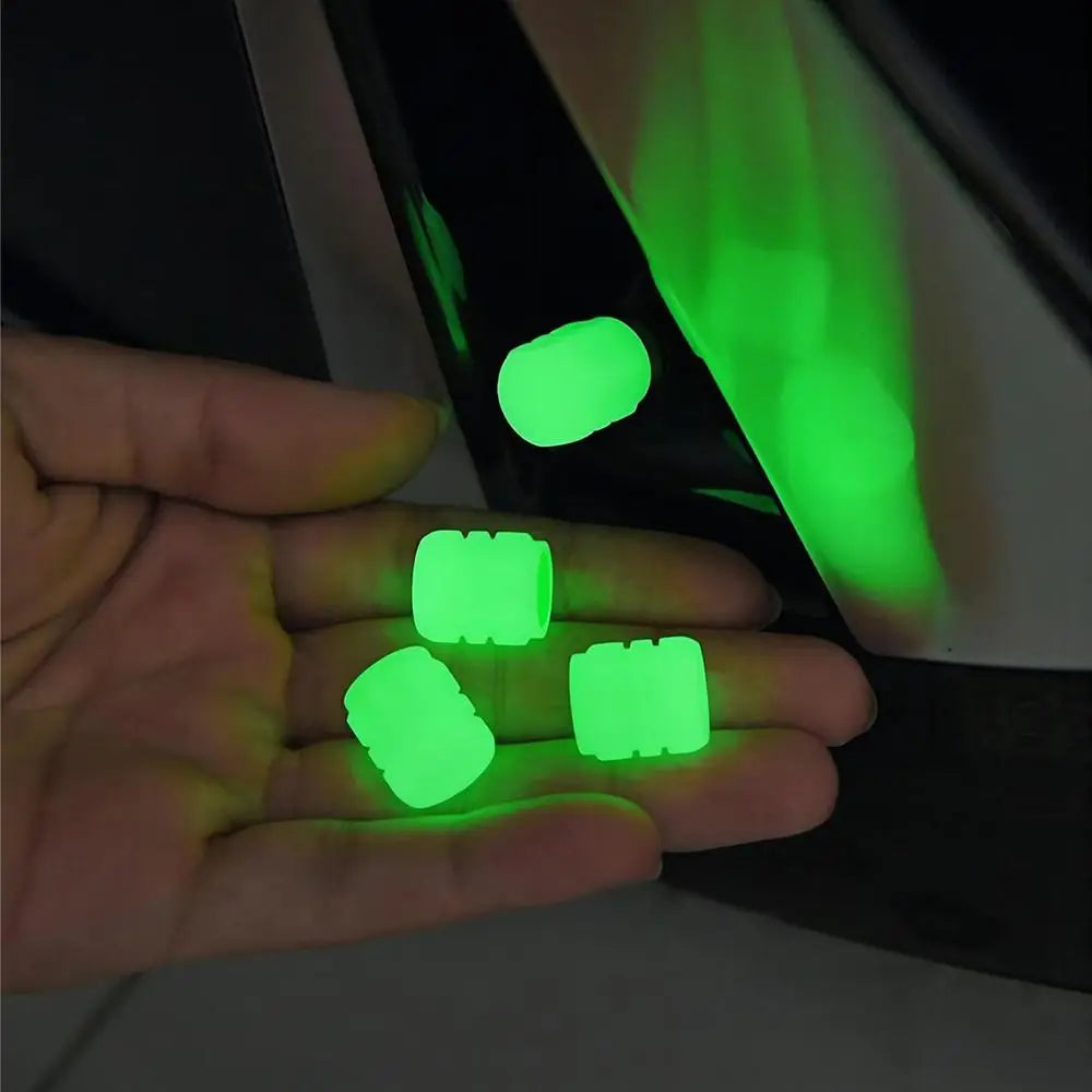 A hand holds several self-luminous green tire valve caps next to a dark object.
