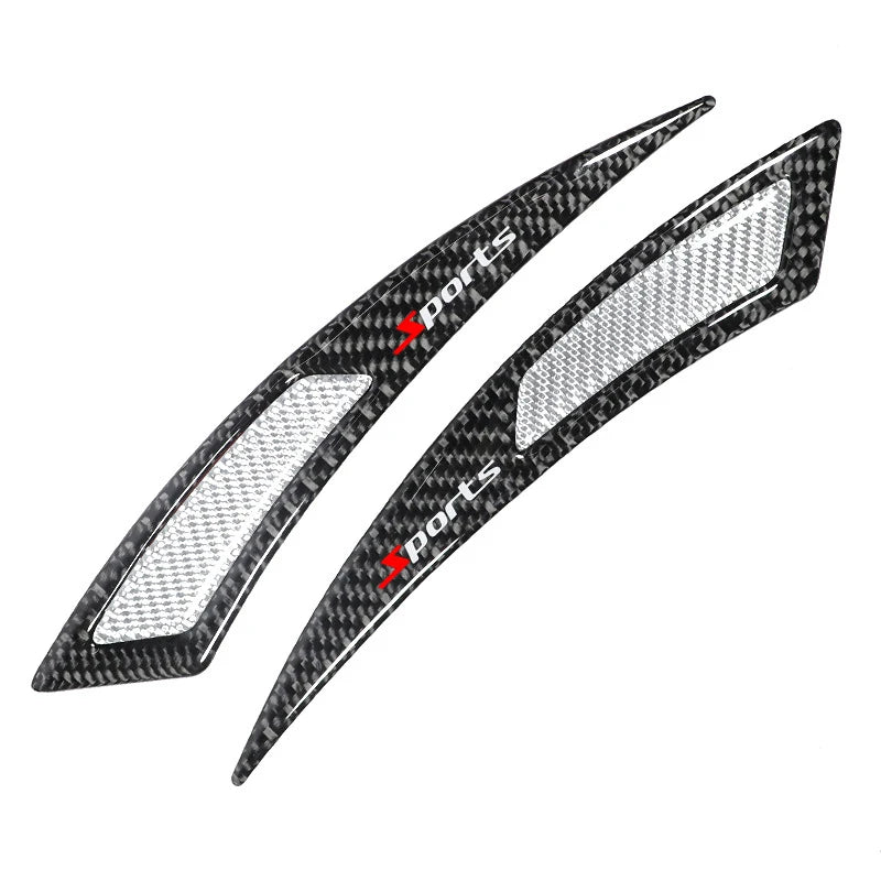 A pair of black carbon fiber sports trim pieces designed as car wheel eyebrow protectors.