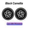 Two black camellia-themed coasters with rhinestone borders