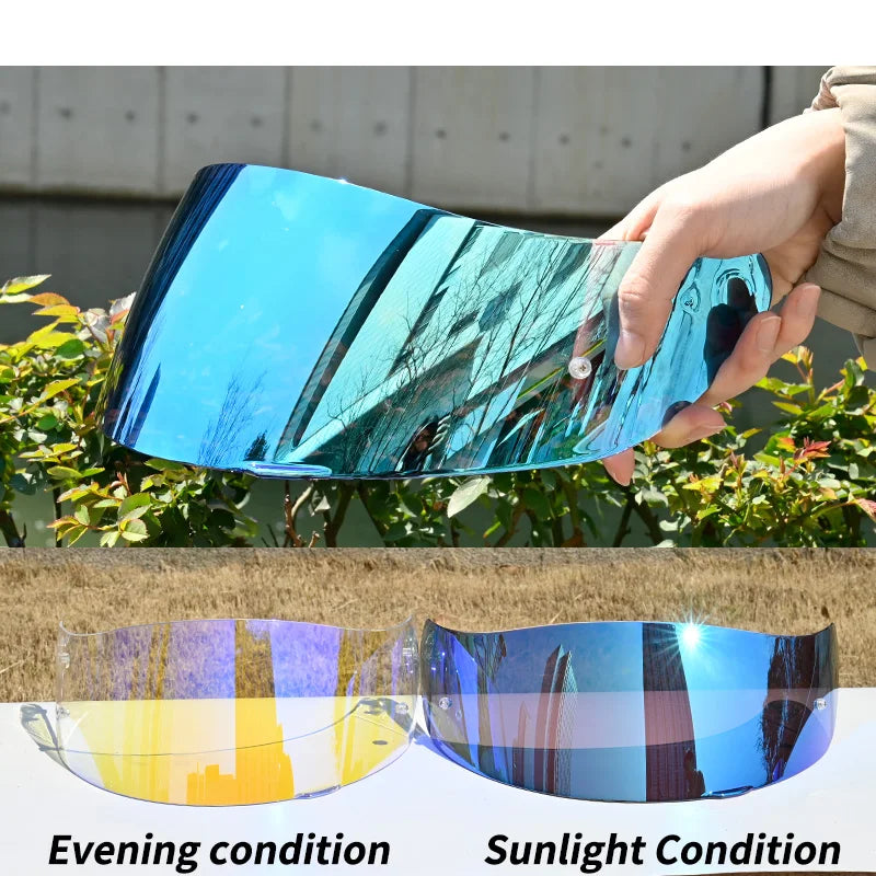A hand holds a curved blue motorcycle helmet visor showing different light conditions, including evening and sunlight.