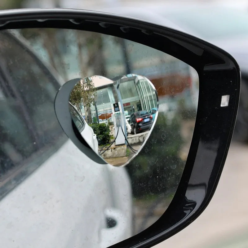 Vue rapprochée d'un miroir angle mort en forme de cœur monté sur une portière de voiture.