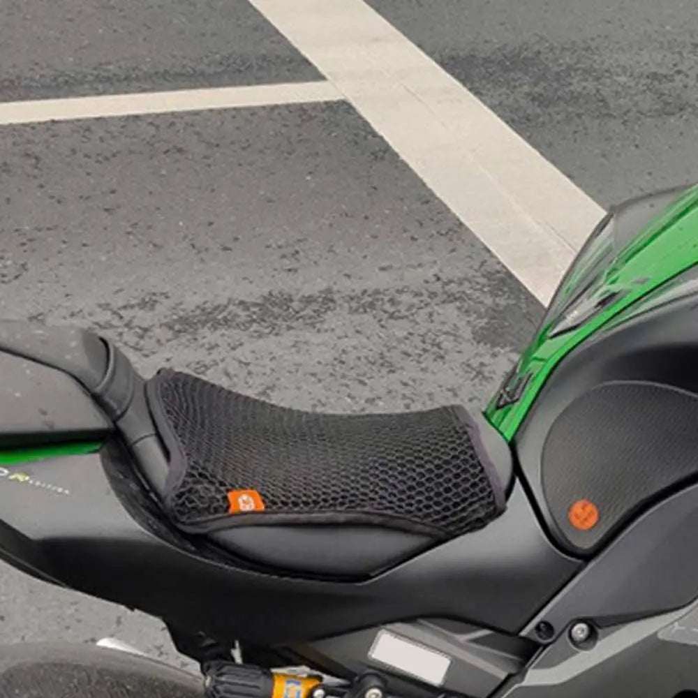Close-up view of a black motorcycle seat with a green accent, showing the seat cushion cover.