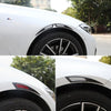 Close-up of a white car wheel with black carbon fiber eyebrow protector trim and tire.