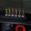 A row of glass tubes containing various colored LEDs, including yellow, green, orange, and red, resting on a dark surface.