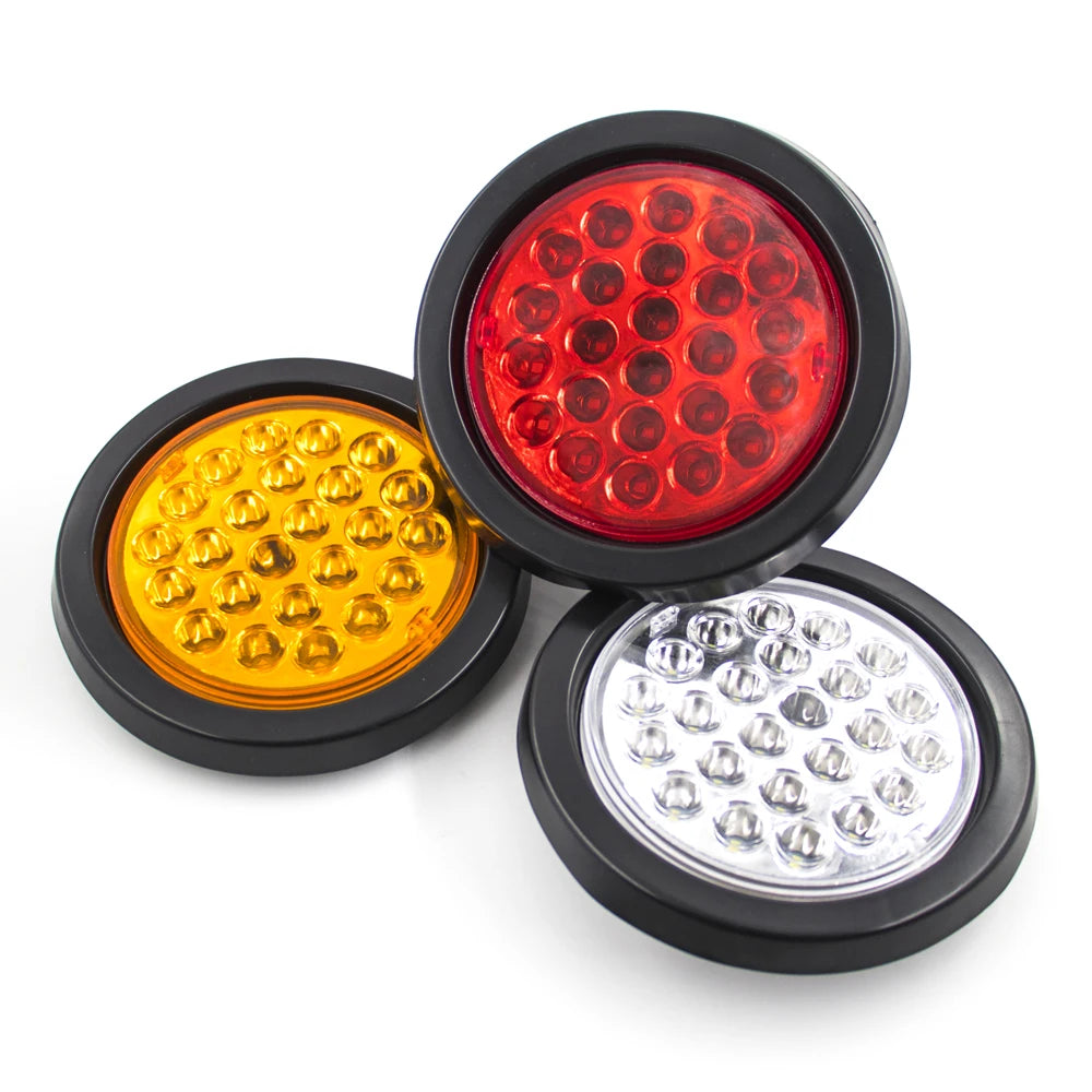 Three round LED trailer lights in red, yellow, and white mounted on a black base.