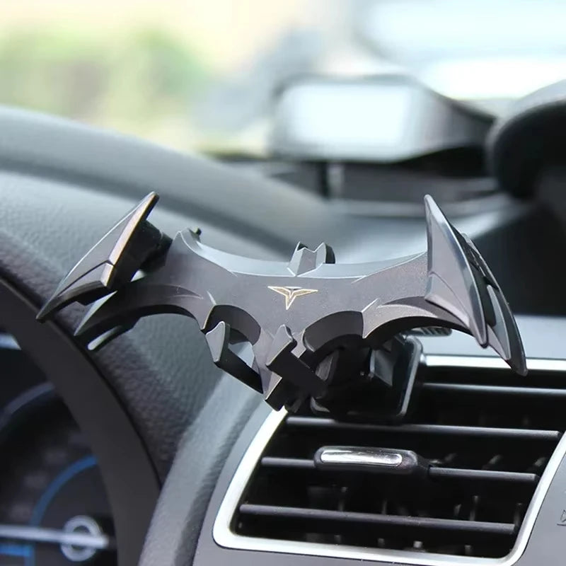 A black gravity expanding car phone holder mount is shown mounted on a vehicle's interior console.