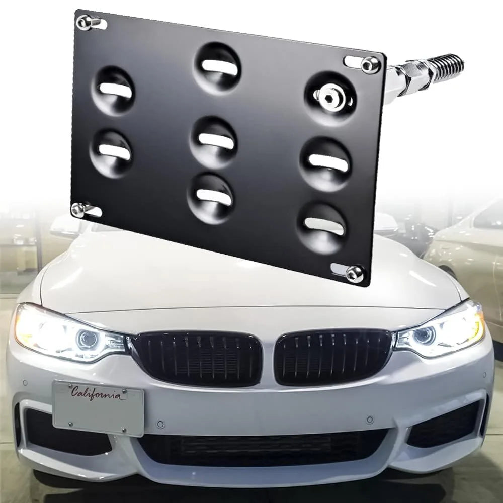 A black license plate mount with multiple round lights is installed on the front of a white BMW car.