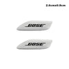 A white, elongated 3D aluminum car audio emblem with the brand name BOSE engraved on it.