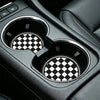 Close-up of a black car interior cup holder with two patterned coasters.