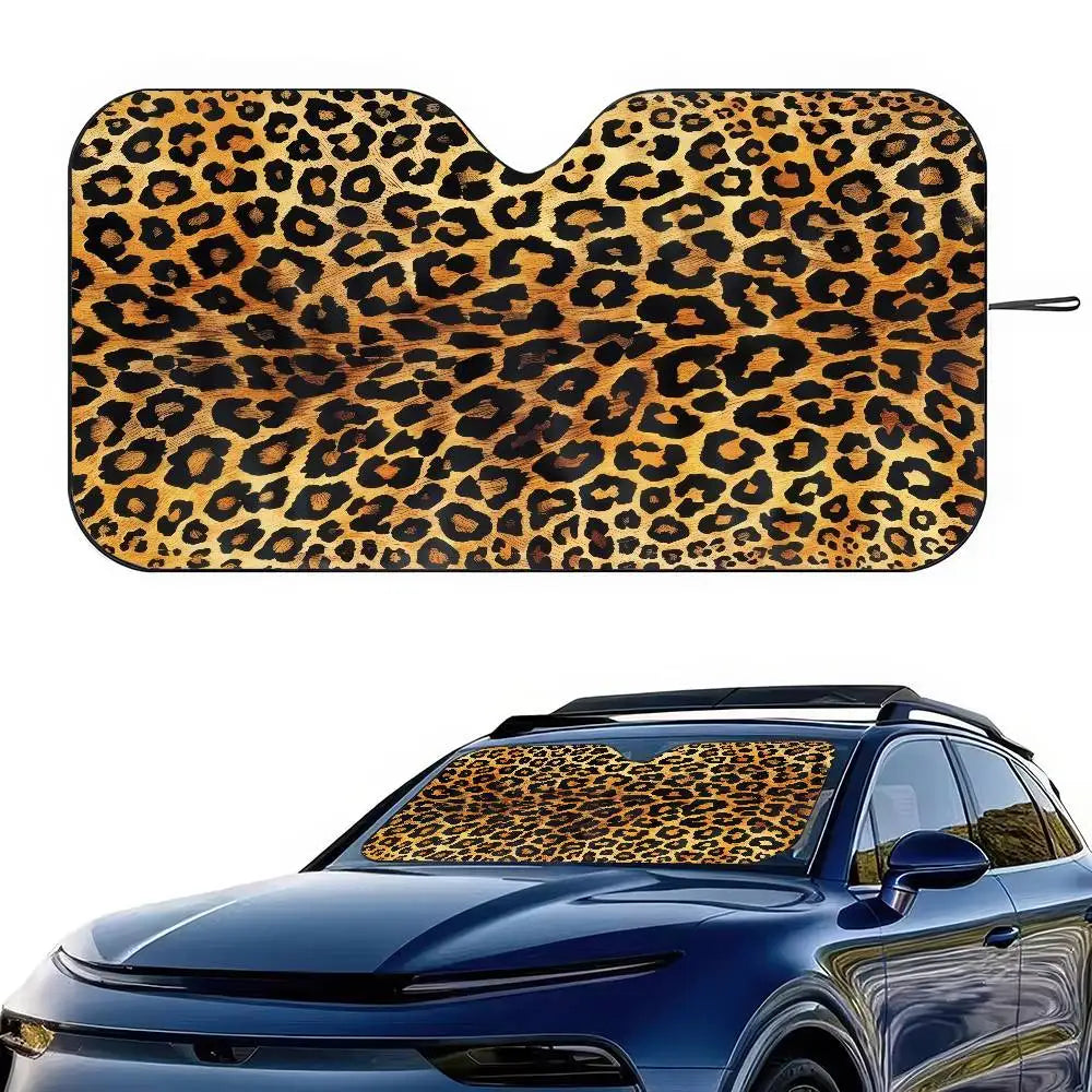 A leopard print car sunshade placed on the front window of a blue car.