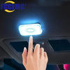 A hand touches a mini wireless LED touch car interior lighting fixture on a vehicle dashboard.