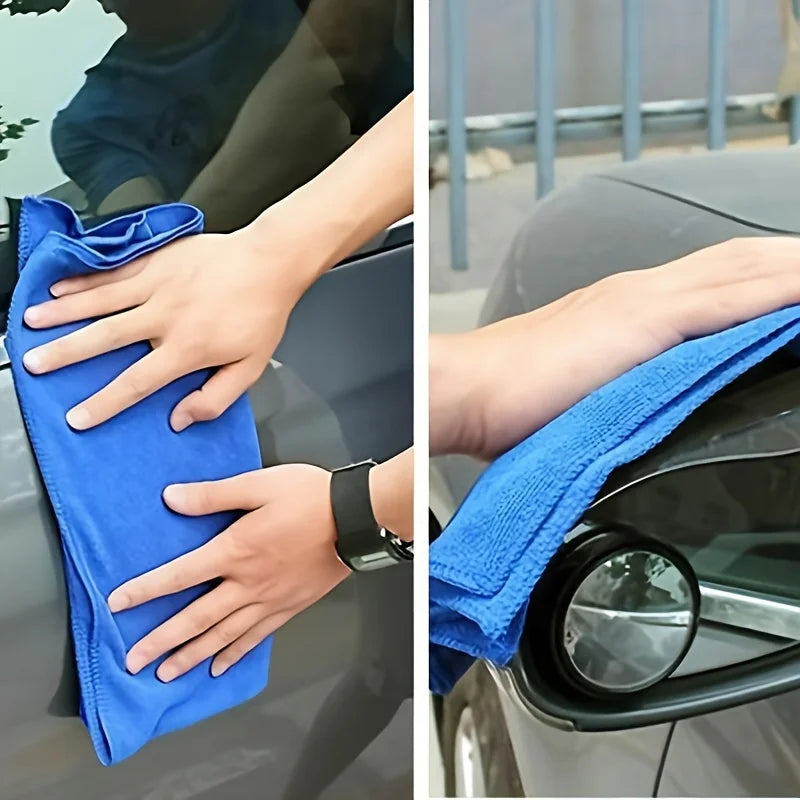 A hand is using a blue microfiber car cleaning cloth to wipe a car surface.