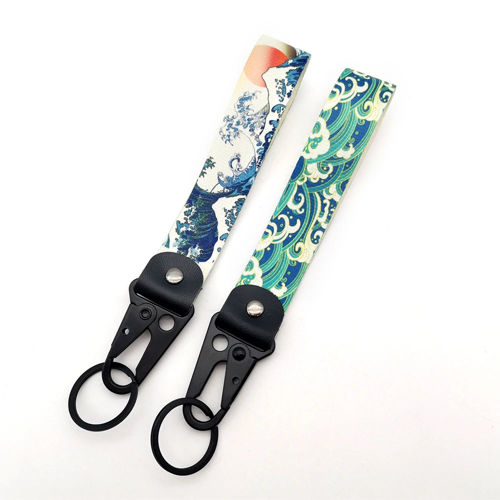 A pair of JDM car keychain lanyards featuring patterned fabric designs.