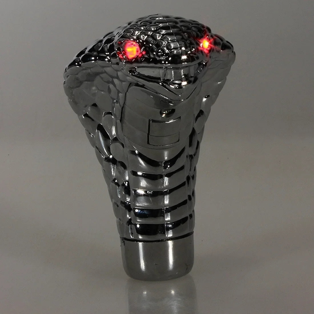 A silver Cobra Snake LED gear shift knob for manual transmissions with glowing red lights.