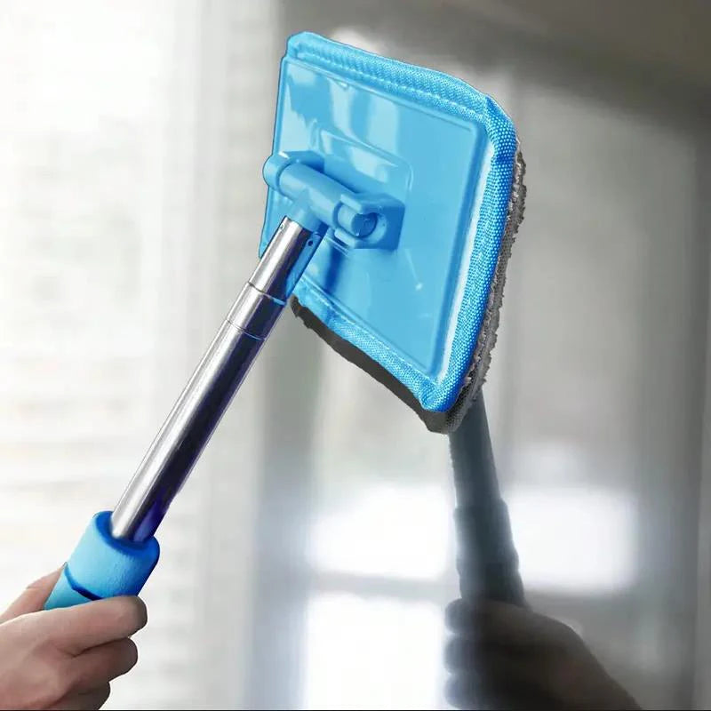 A hand holds a blue telescopic windshield cleaning brush with a square head for automotive glass.