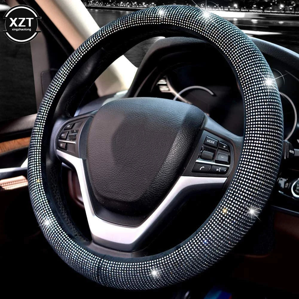 A close-up view of a black steering wheel covered in sparkling crystal rhinestones.