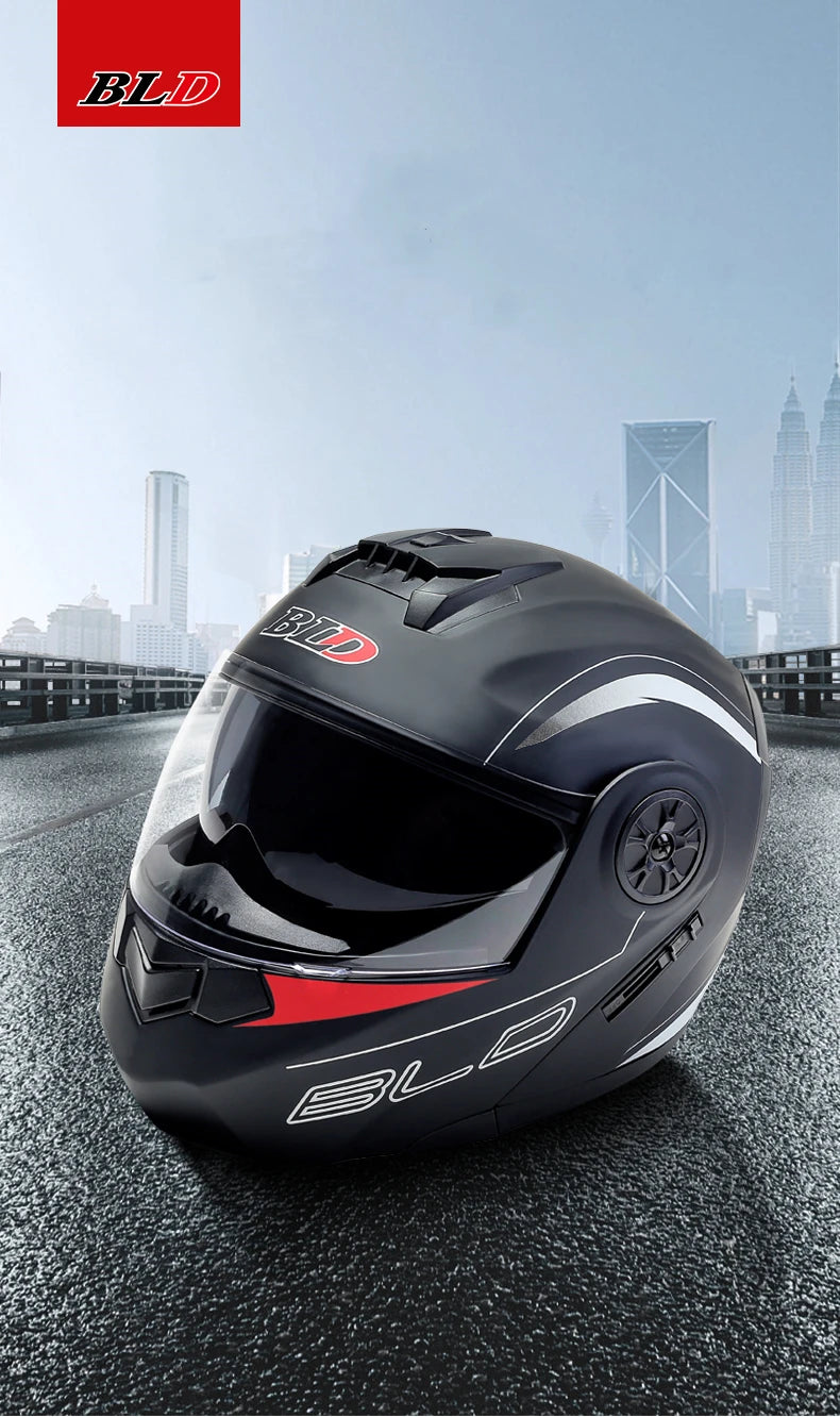 A black motorcycle helmet with a clear visor and red accents is shown on an asphalt surface.