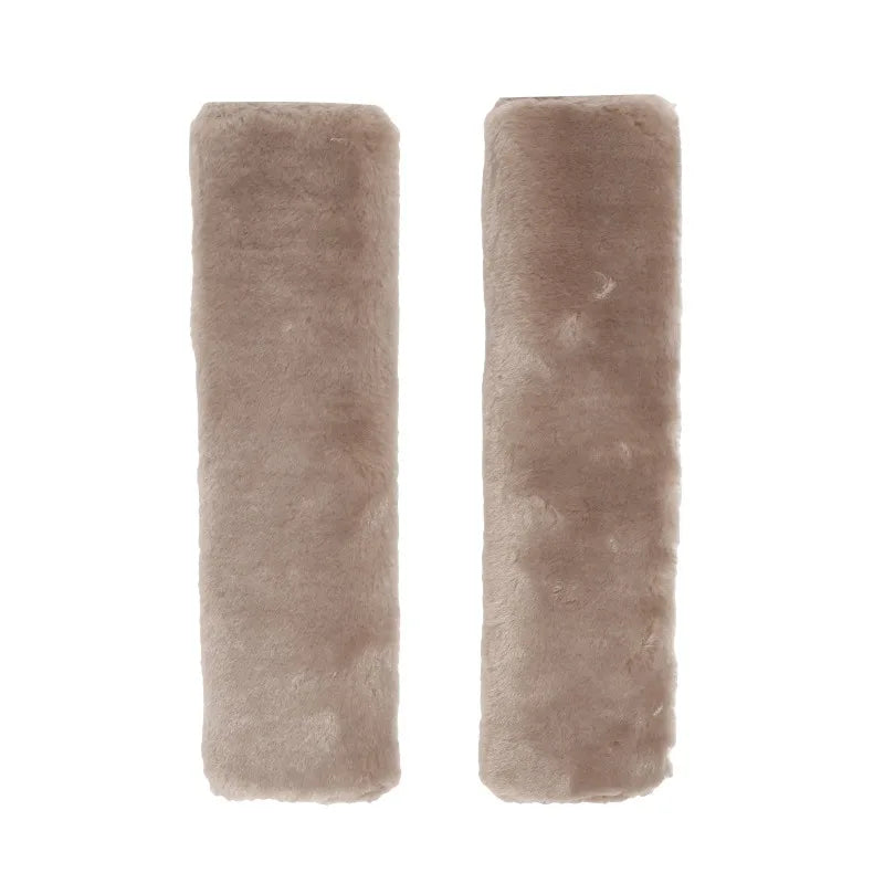 Pair of tan luxury car seatbelt shoulder pads.
