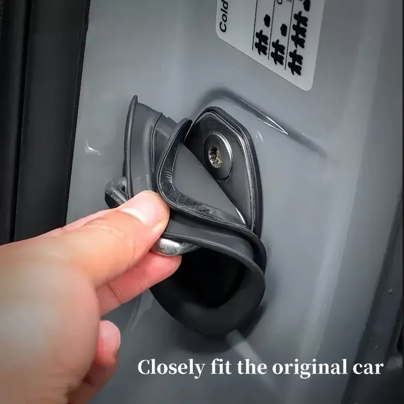 Une main ajuste un protecteur de serrure pour porte de voiture sur un panneau de porte.