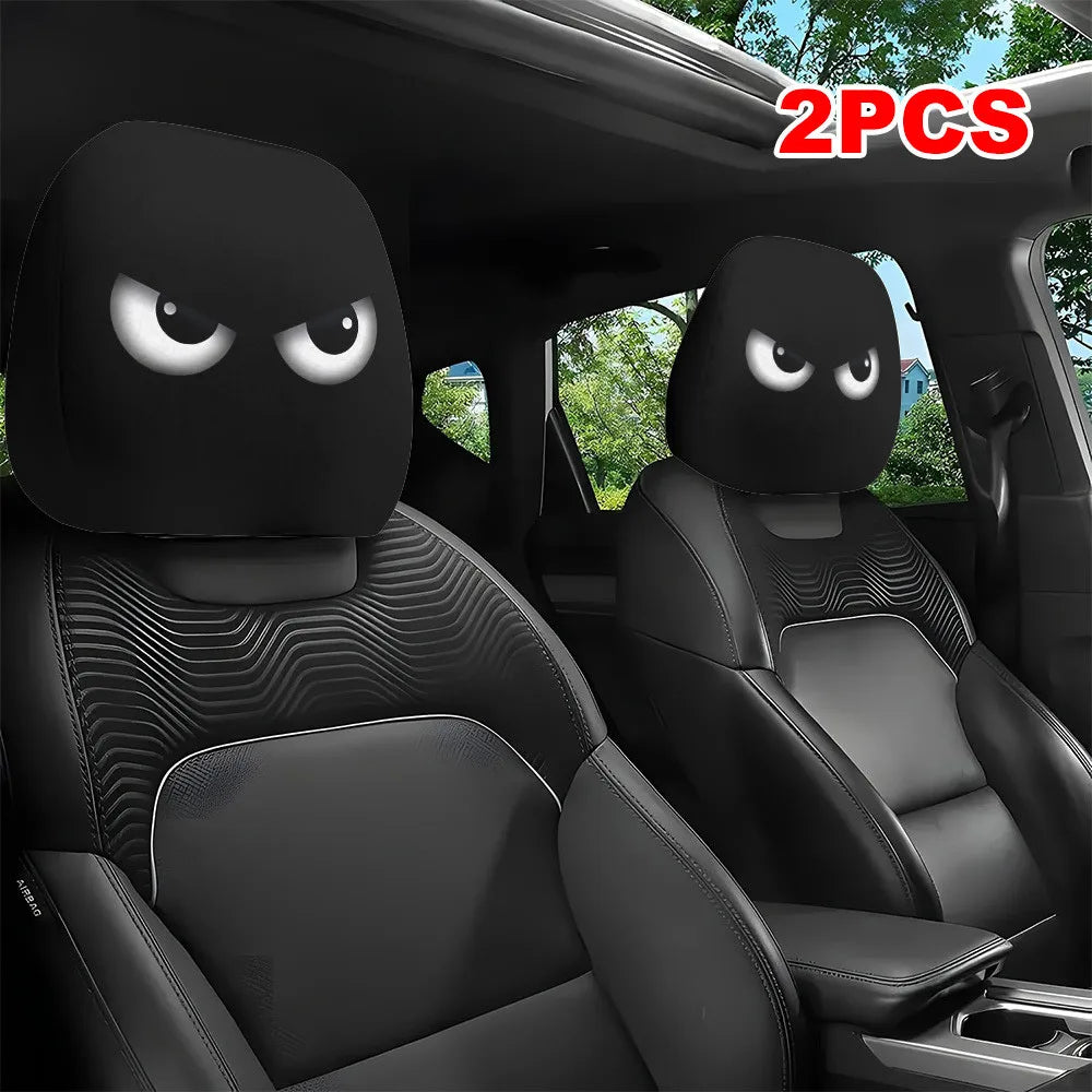 A pair of black car headrest covers with funny slanted eyes are shown inside a vehicle seat.