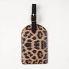 A black leather passport holder with card slots featuring a leopard print design.