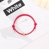 A red heart-shaped fitness tracker bracelet is displayed on a white background next to a black label.