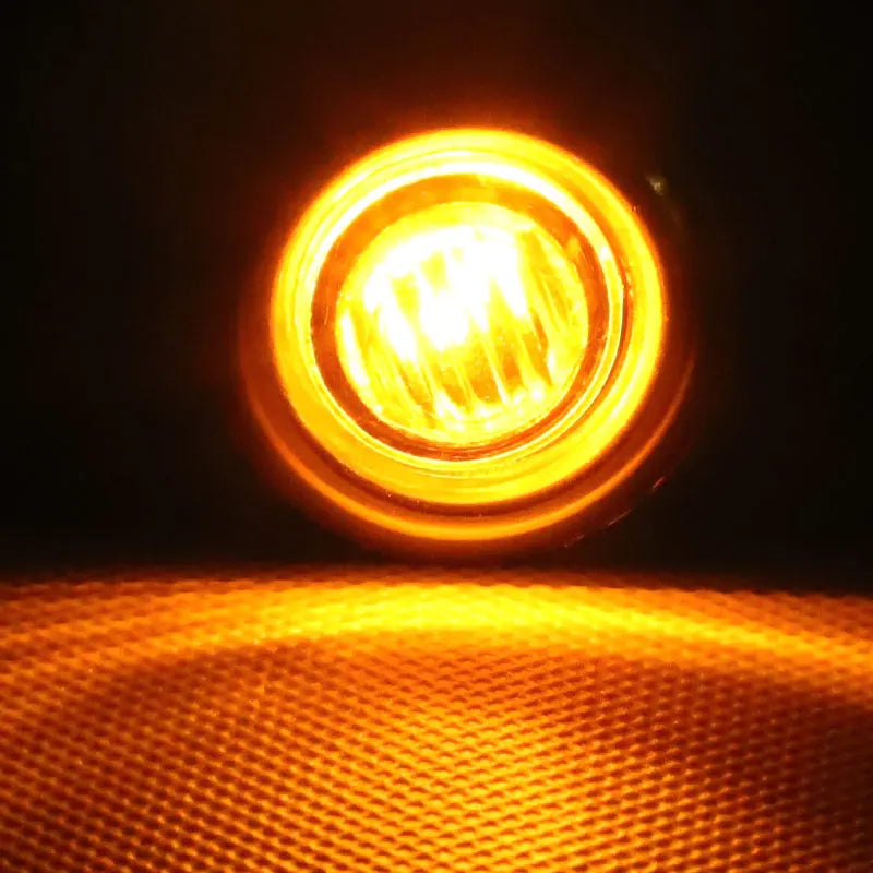 Close-up view of a bright yellow LED marker light illuminating a textured orange surface.