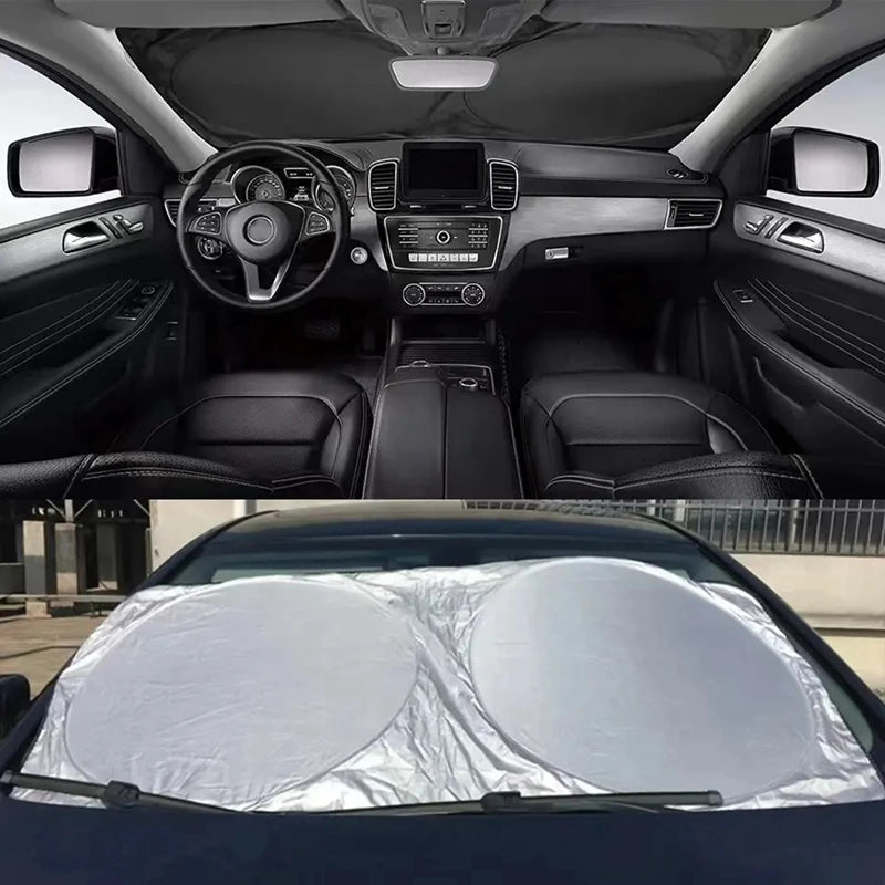 A white windshield sun shade visor protector is shown placed on the glass of a dark car.